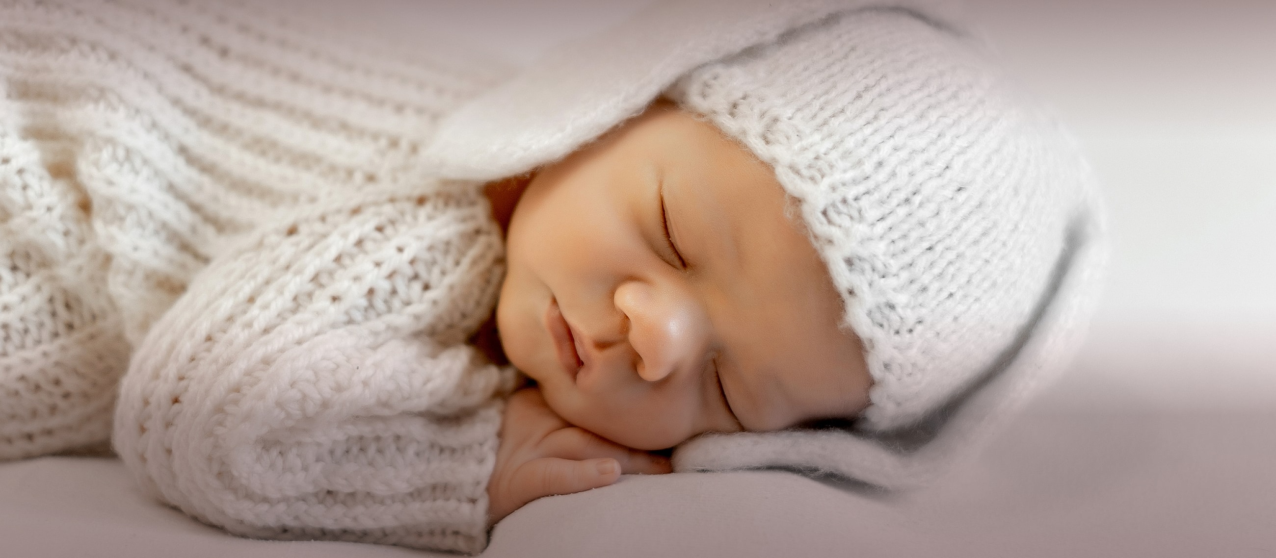 Baby sleeping in knit bunny hat and outfit.