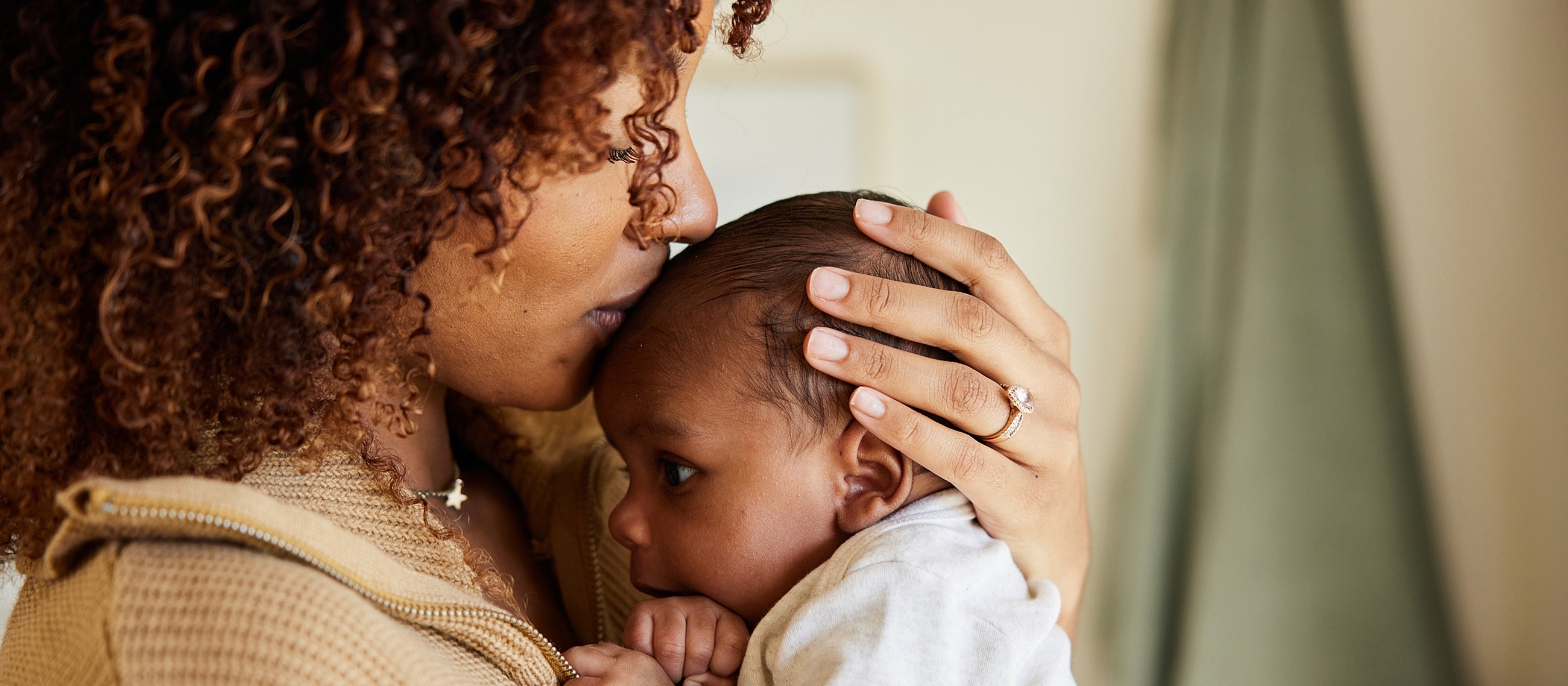 Mother cuddling baby in warm embrace.