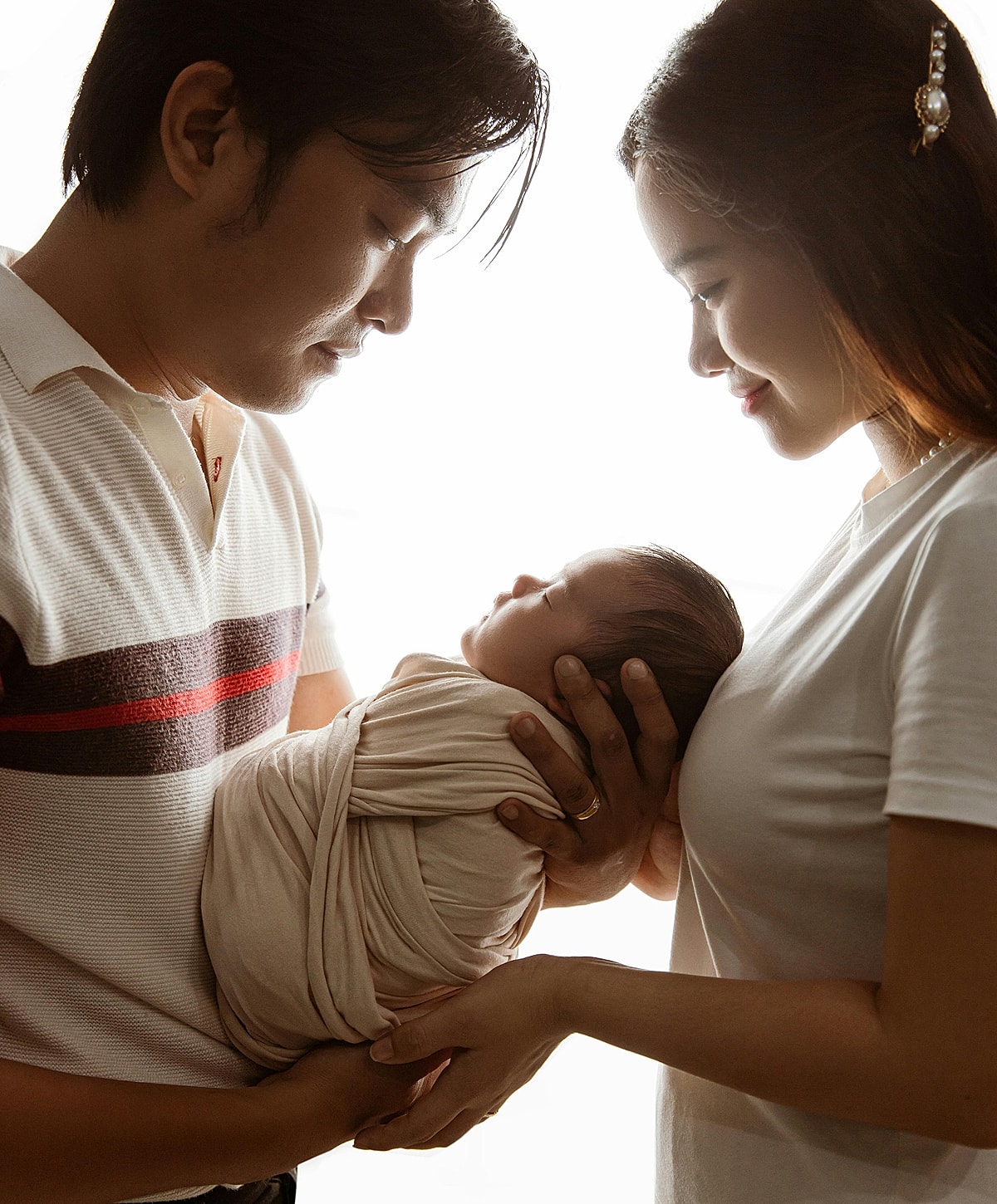 New parents with their sleeping baby.