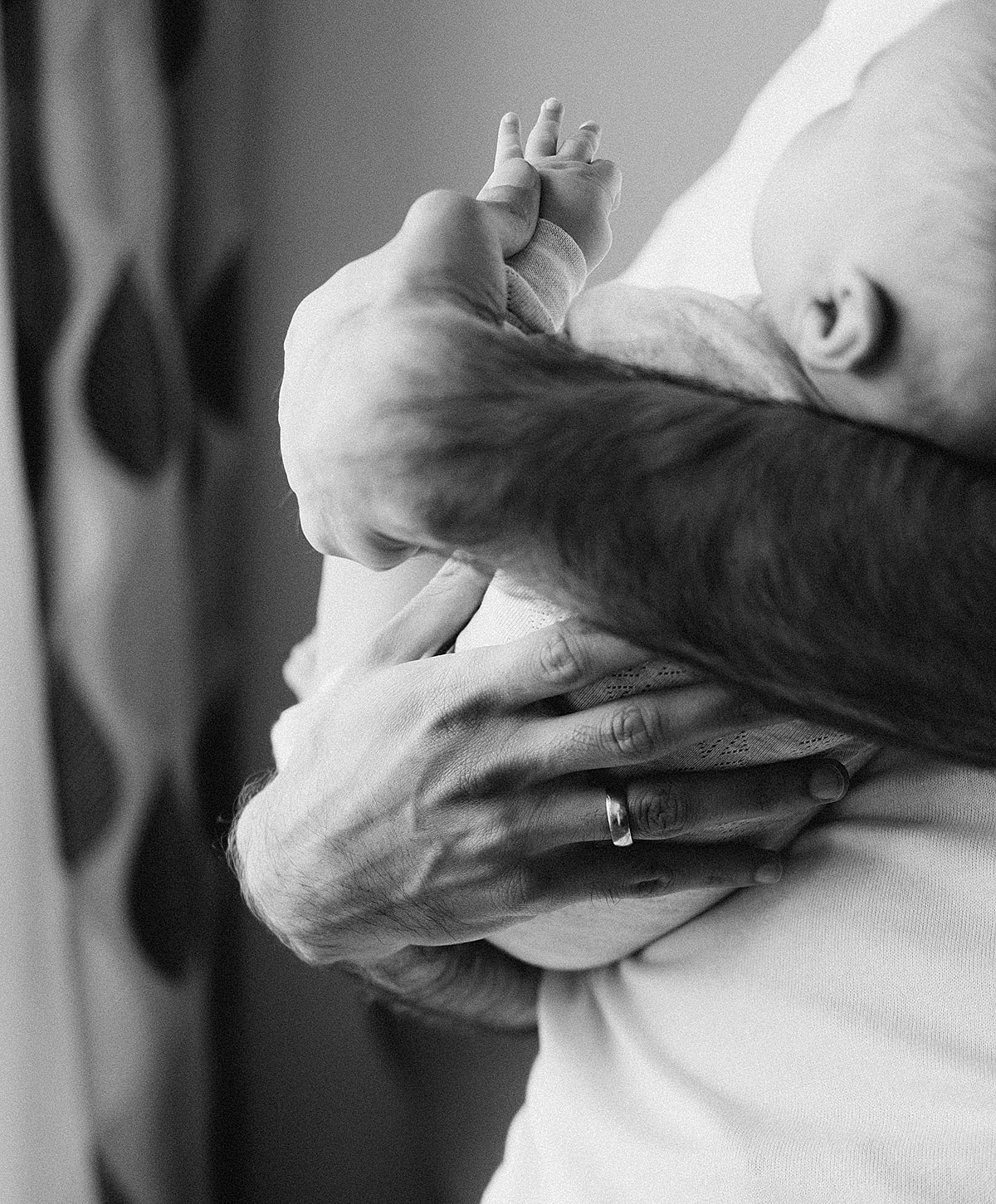 Father holding baby in black and white photo.