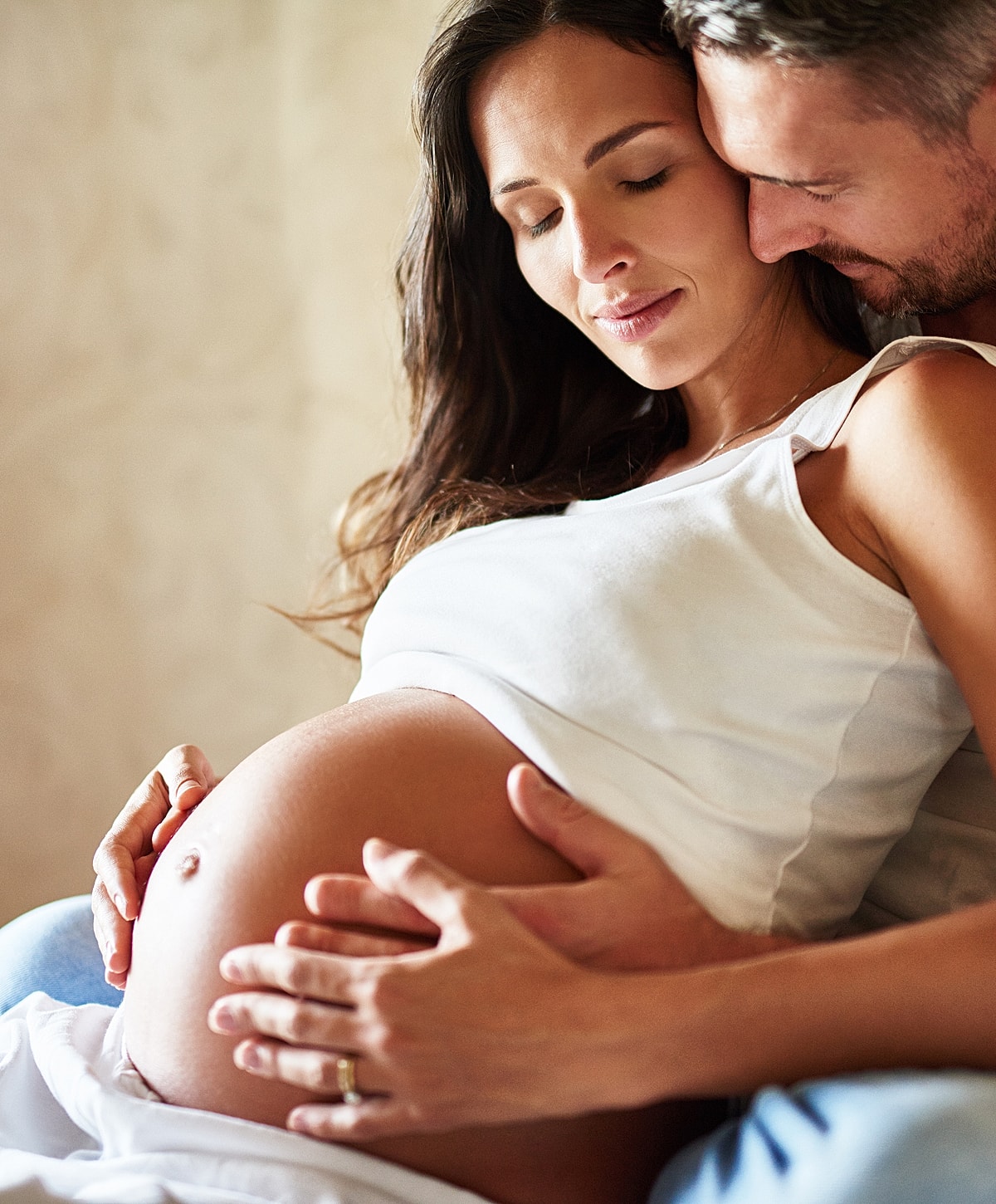 Couple embracing pregnant belly with love.