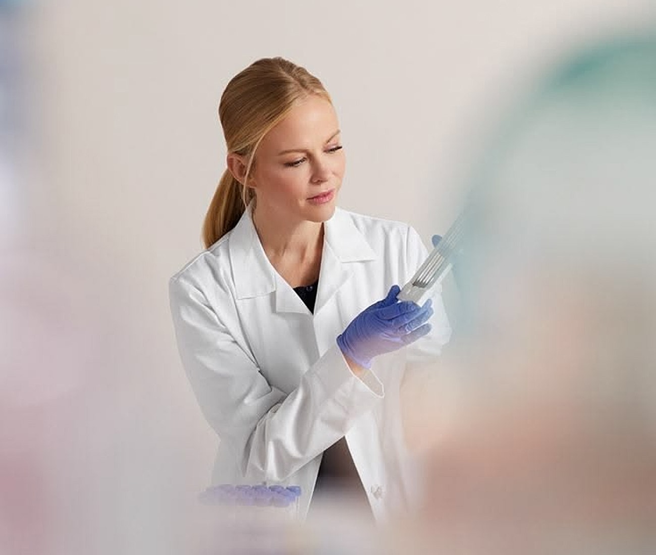 Woman in lab coat handling laboratory equipment