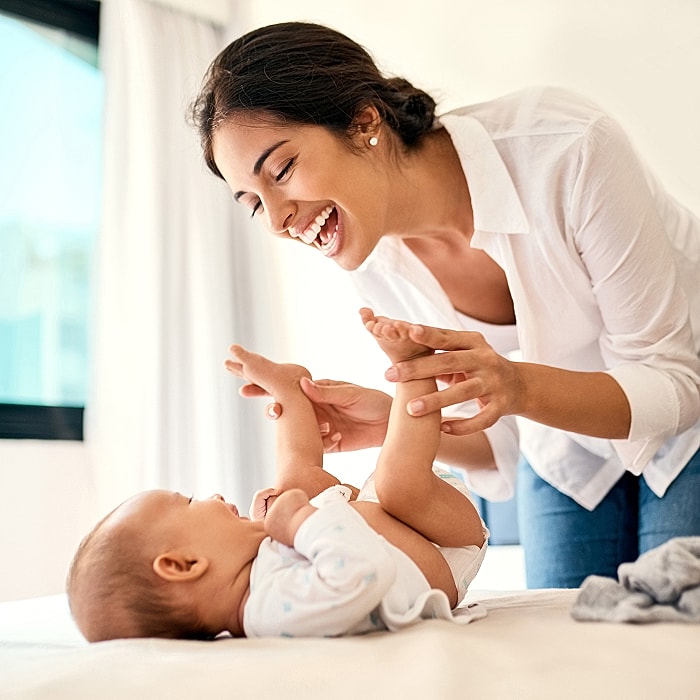 Mother playing joyfully with her baby.