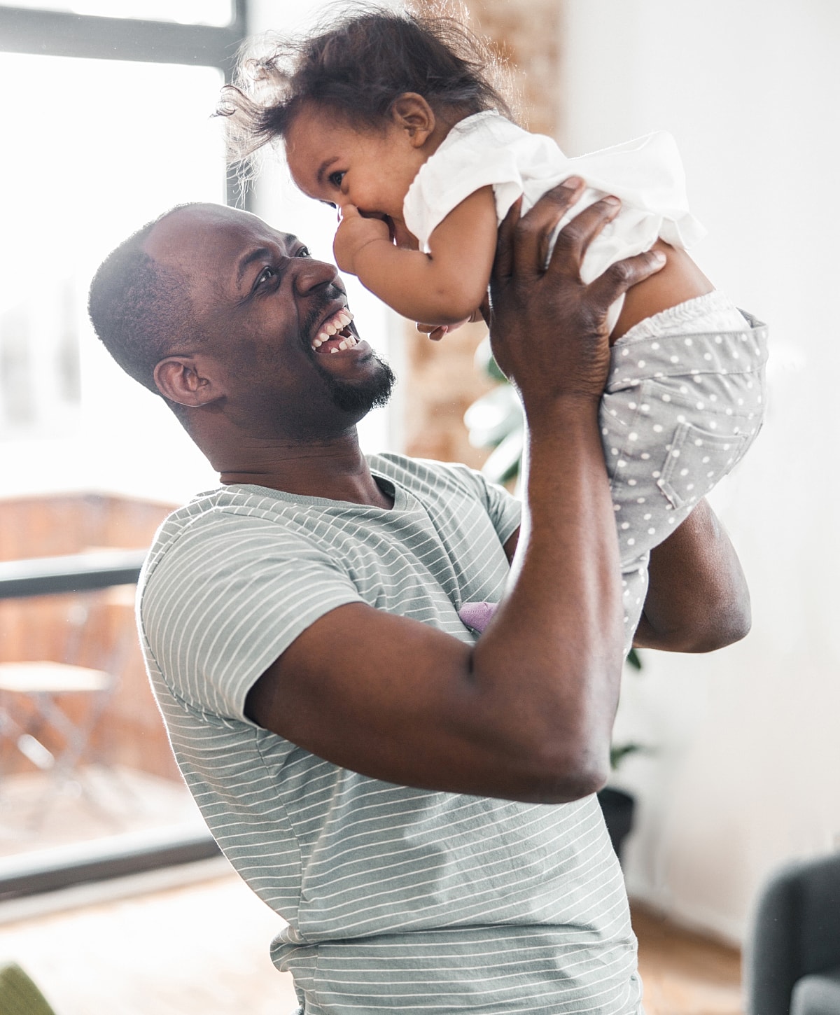 Happy father playing with his joyful baby.