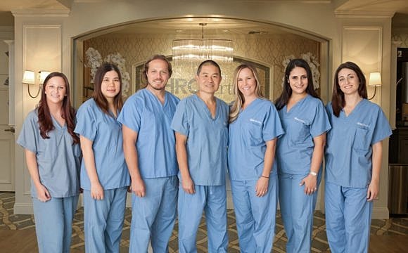 Medical team posing in scrubs indoors.