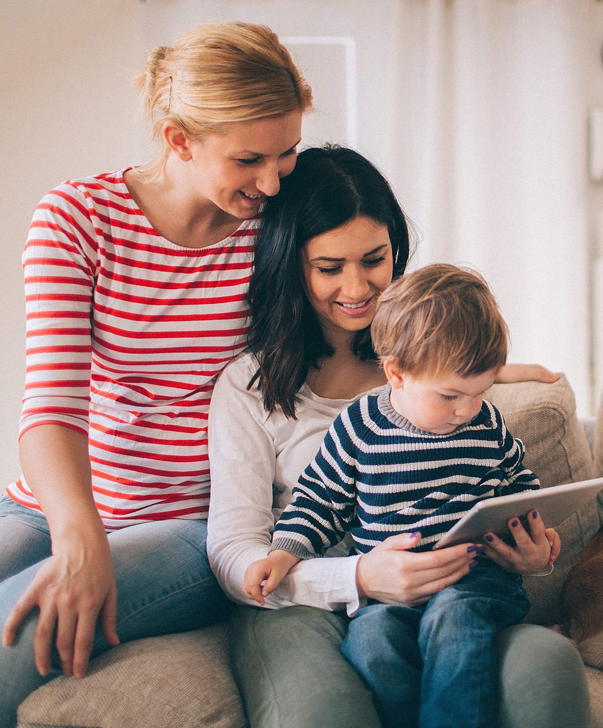 Two women and a child using a tablet.