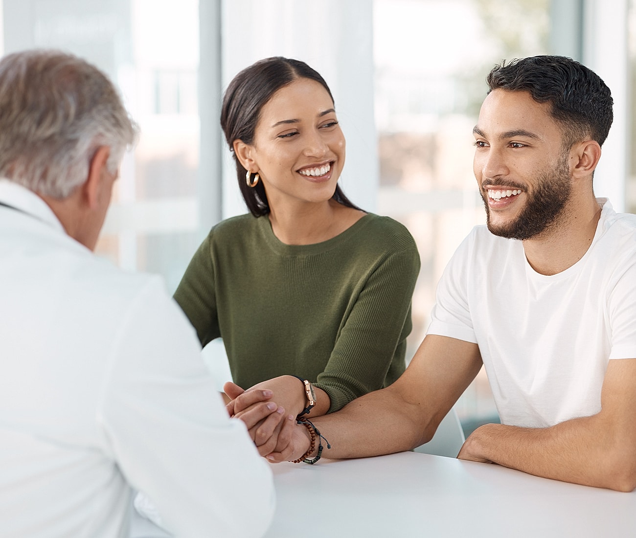 Couple smiling during a consultation with doctor.