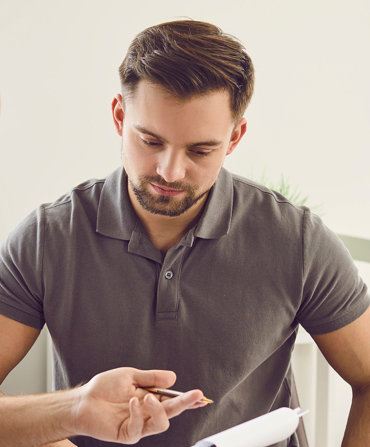 Man studying notes with a pen in hand.
