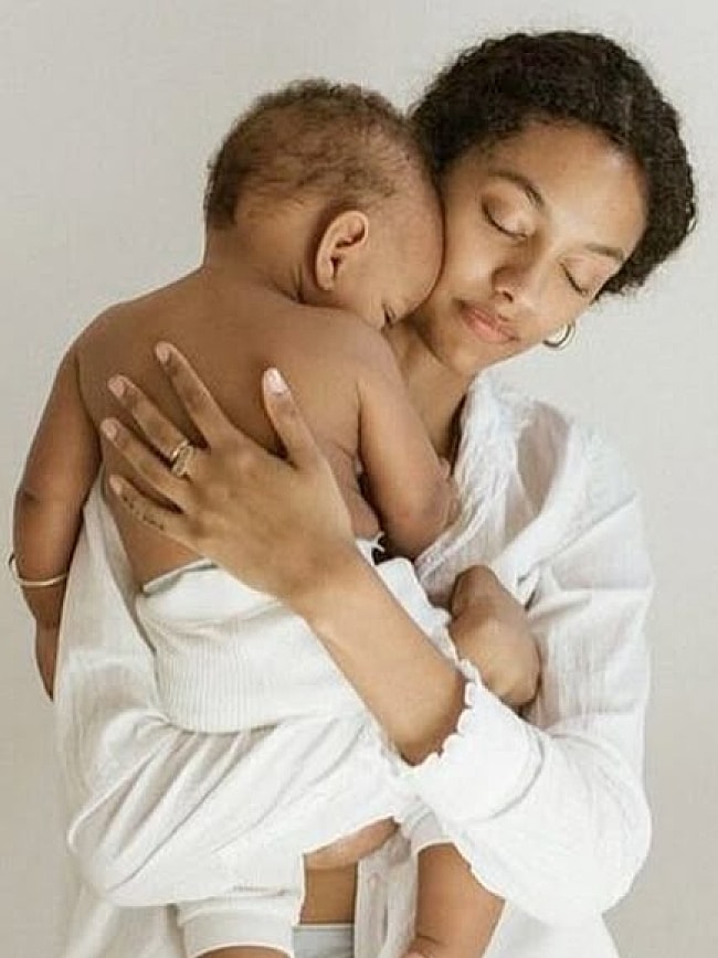 Father kissing his baby, sharing a moment.