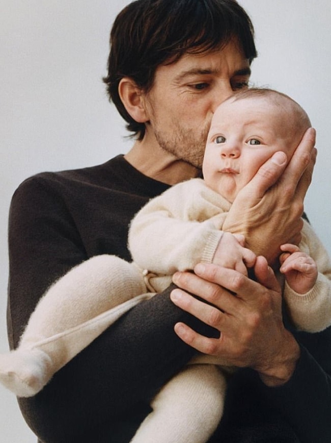 Hands holding a baby's feet tenderly.