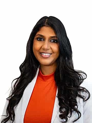Smiling professional woman in white lab coat.