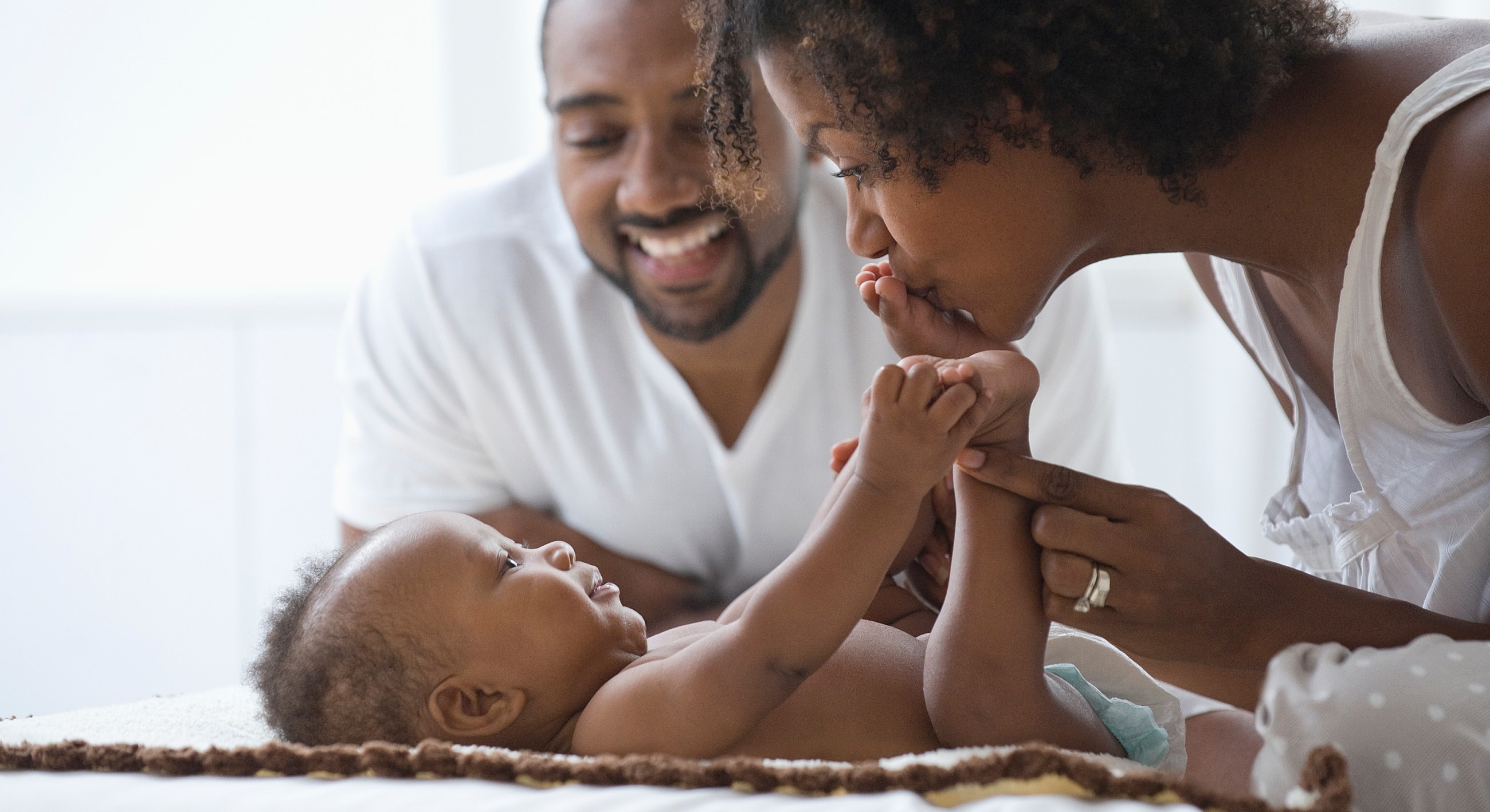 Family bonding time with baby on a blanket.