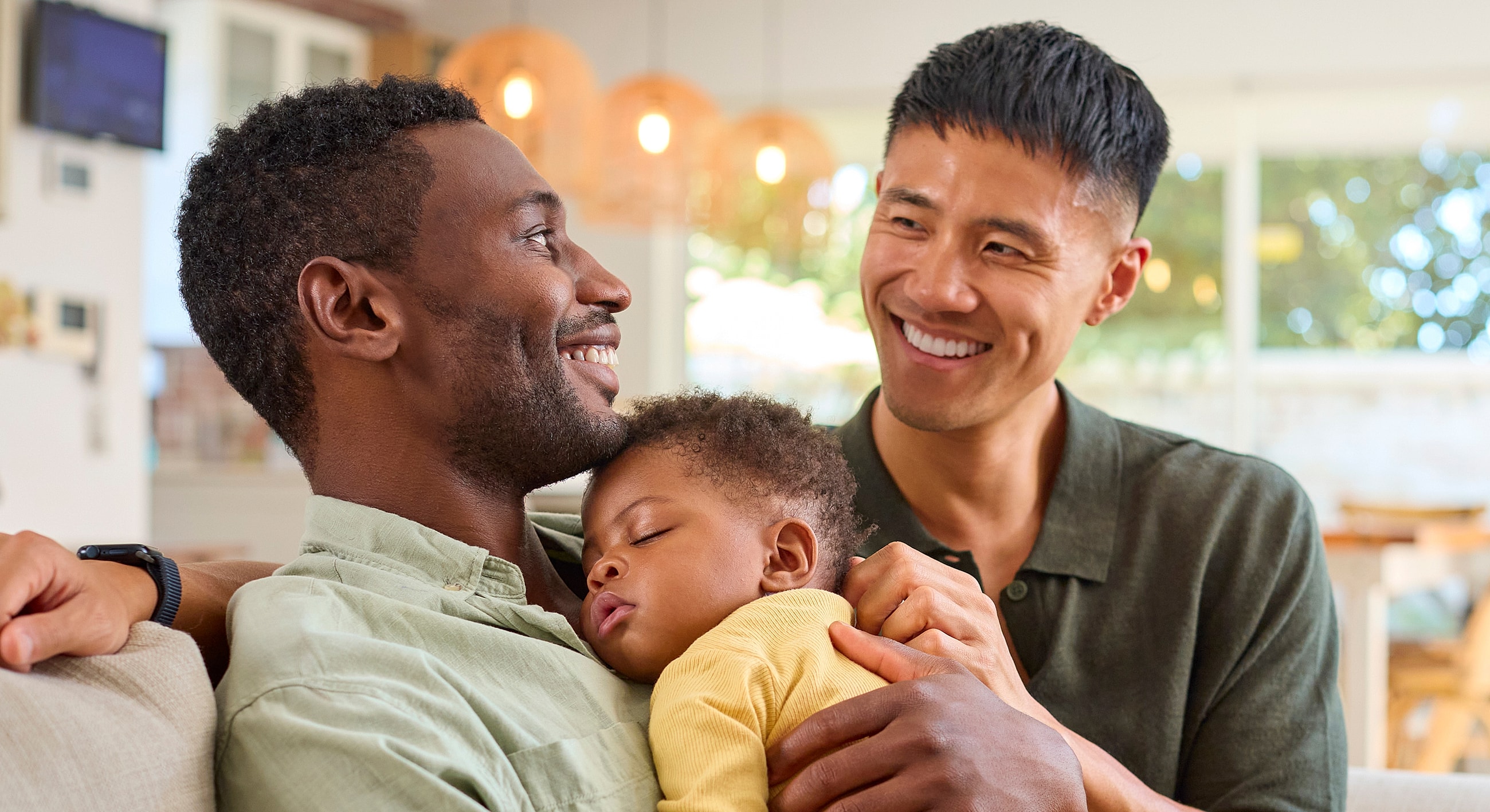 Two fathers enjoying a moment with their baby.