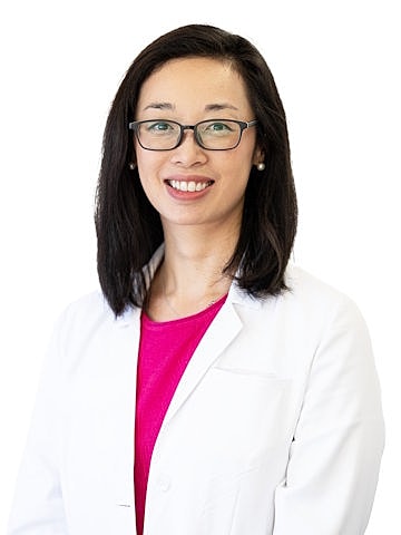 Smiling doctor in a white coat and glasses.