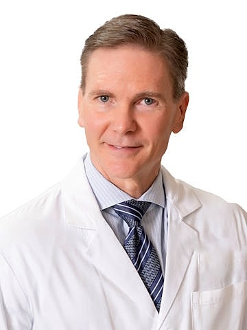 Professional in lab coat and tie.