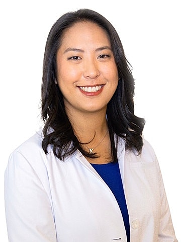 Smiling professional in medical attire.