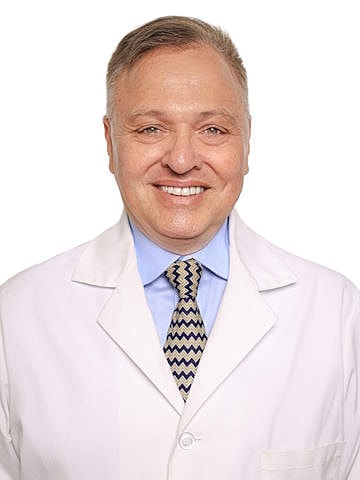 Smiling doctor in white coat with tie.