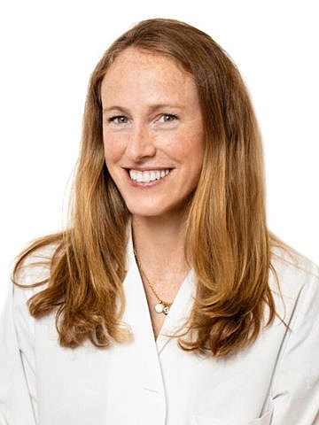 Smiling woman in a lab coat.