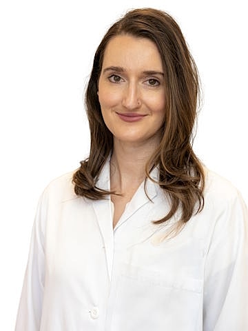 Smiling woman in a lab coat.