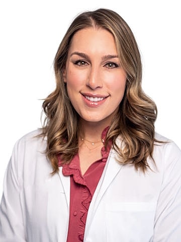 Female doctor smiling in white coat.