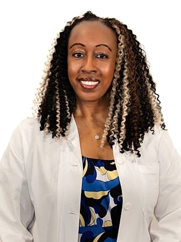 Smiling professional woman in medical attire.
